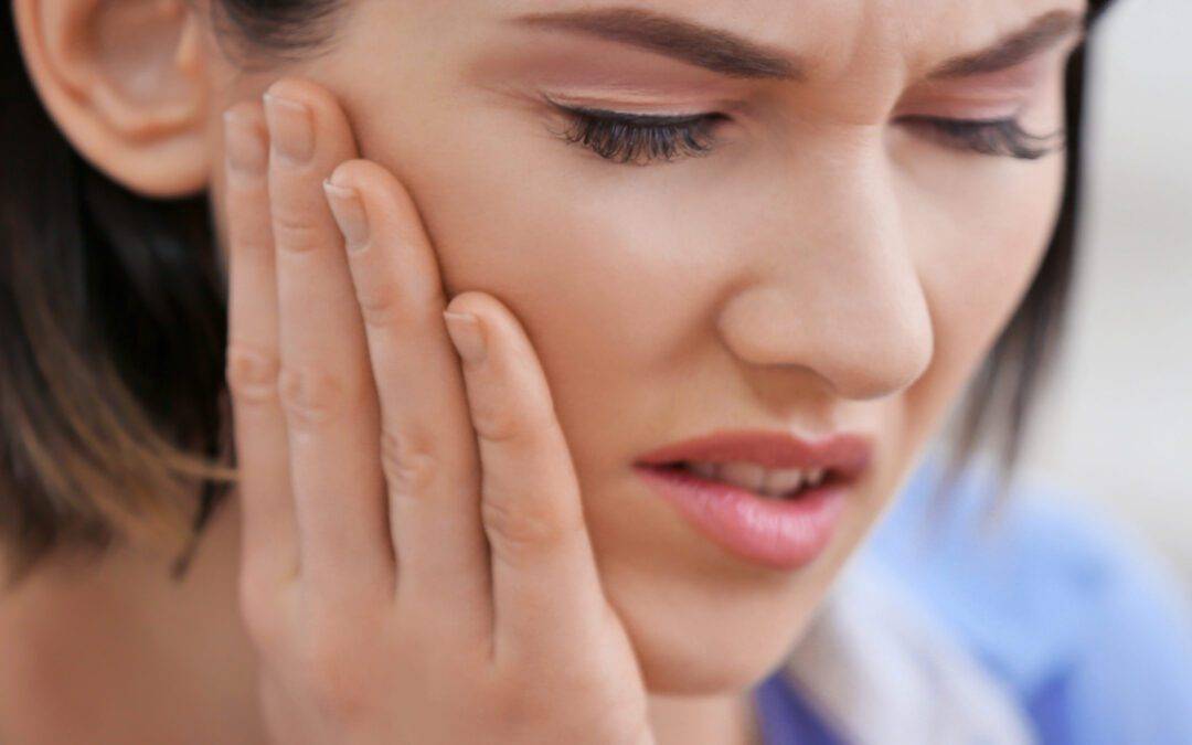 Beautiful young woman suffering from toothache, close up