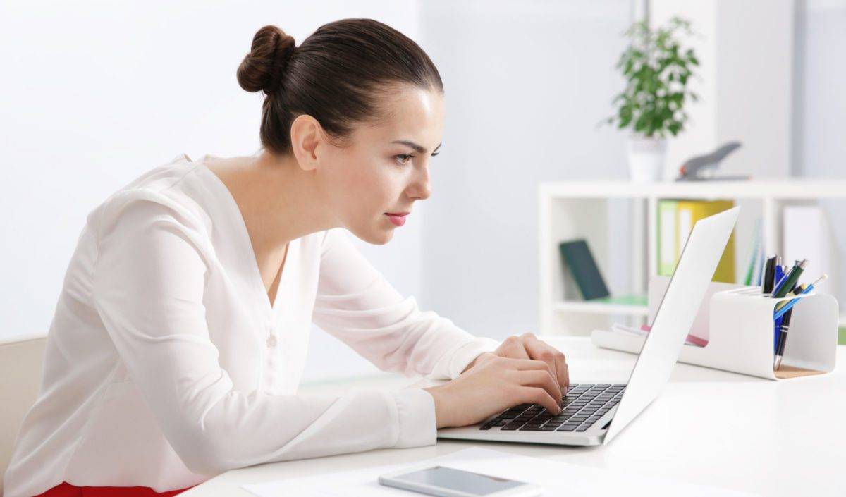 Incorrect posture concept. Young woman sitting at table in modern room