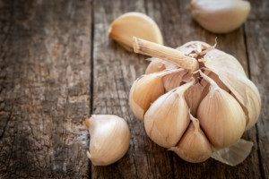 Dried garlic with garlic cloves on old wooden table.