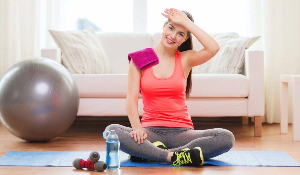 smiling girl with bottle of water after exercising